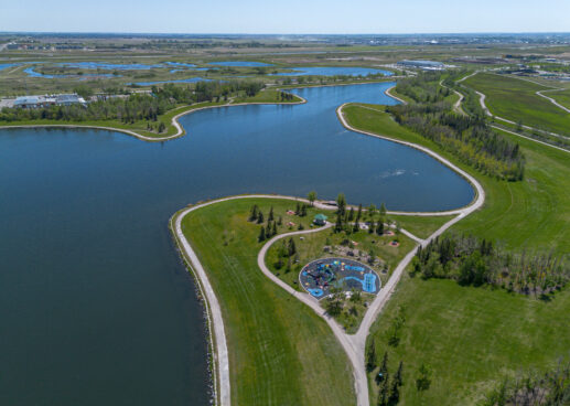 drone view of lake, green space, and playground