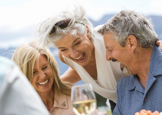 Friends having fun and laughing over glass of wine